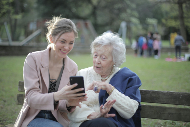 Older lady and young woman sitting on garden bench