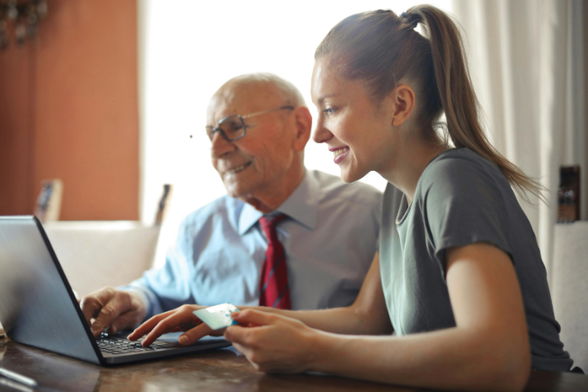 older couple and young woman working on laptop